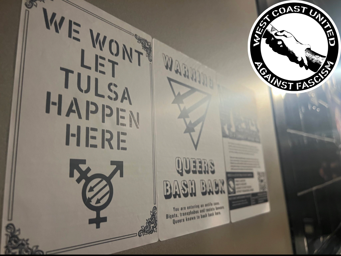 A wall with a light glaring off of three posters. From left to right, they read "We wont let Tulsa happen here." with a queer front symbol at the bottom. The second image reads "Warning, Queers bash back. You are entering an antifa zone. Bigots transphobes and racists beware. Queers known to bash back here." A Queer Front is displayed across the middle. In the distance is a dark flyer with text on it. It is too difficult to read against the glare.